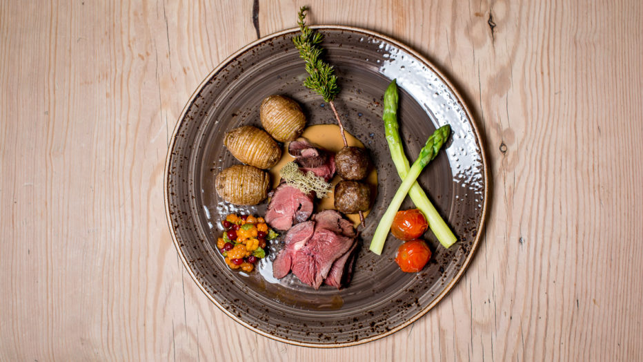 Reinsdyrstrilogi: varmrøyket lår, rosastekt lår og kjøttboller. Servert med asparges og cherrytomatconfit​ og kompott av moltebjærk, små bjørkeløv og tyttebærmarmeldade.