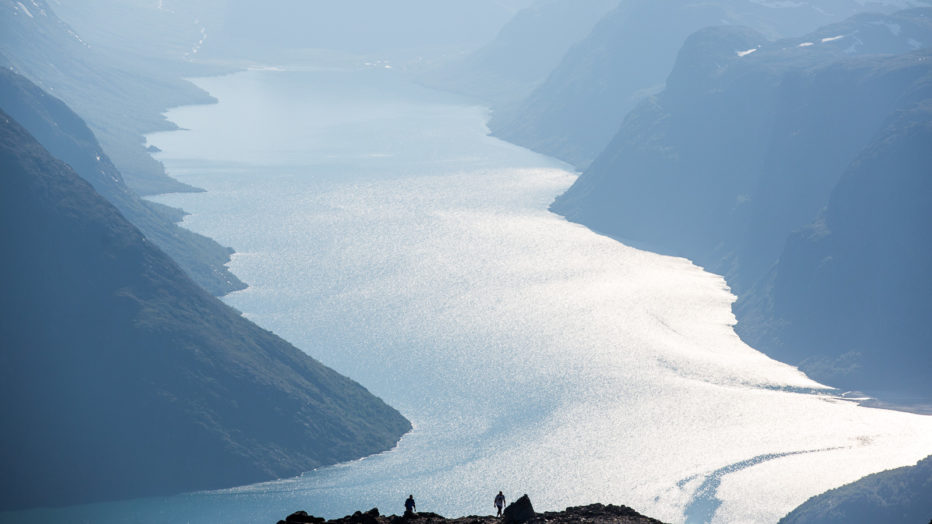 Fotturister opp Besseggen, en av Norges mest populære fjellturer. I bakgrunnen ligger Gjende og Gjendebu.